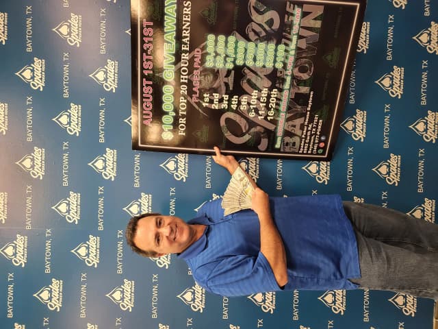 Spades Baytown $10,000 giveaway winner with cash backdrop